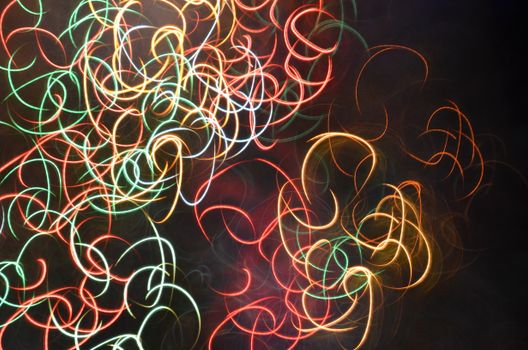 Abstract light trails of various colors on a dark background create a vibrant and dynamic pattern.
