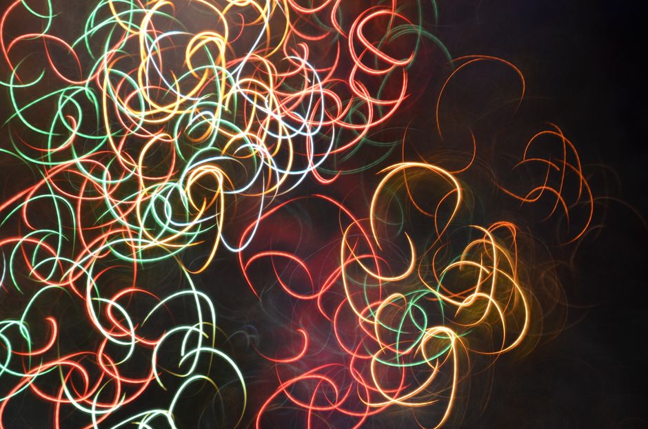 Abstract light trails of various colors on a dark background create a vibrant and dynamic pattern.