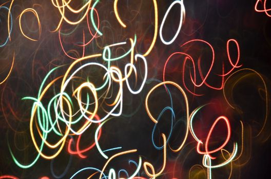 Vibrant abstract design with colorful light streaks swirling against a dark backdrop.