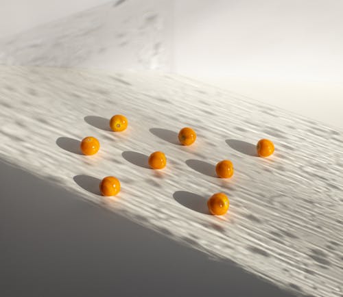 Sweet yellow ripe cherry tomatoes arranged on white surface in shadows in light studio