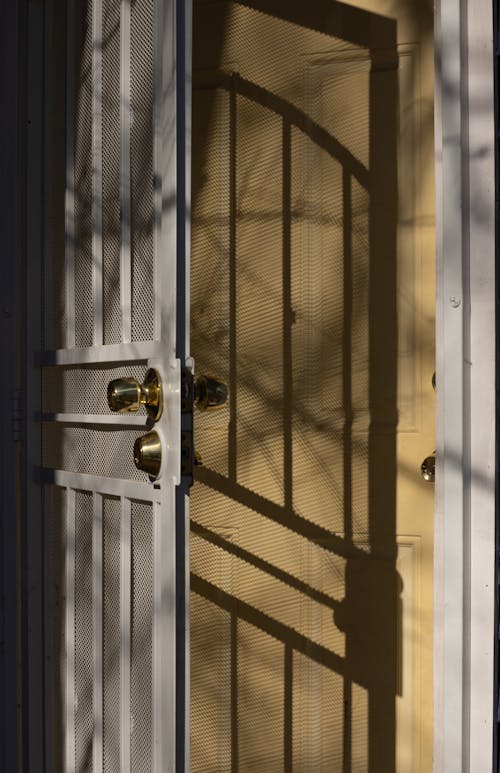 Free Metal gate and wooden door in sunlight Stock Photo