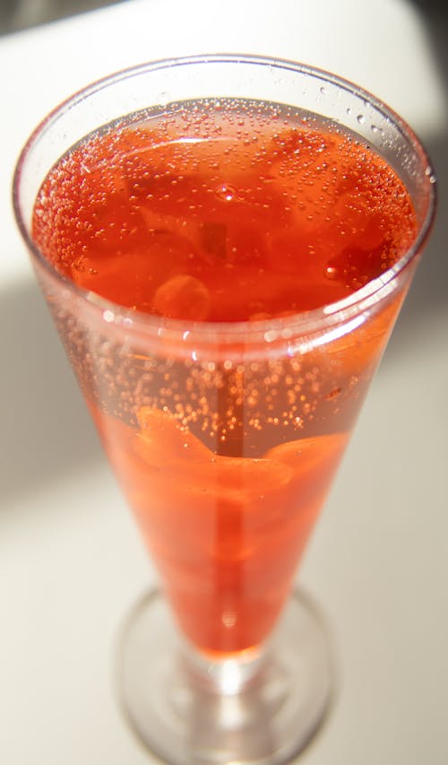 Free Glass of cold red cocktail placed on white table Stock Photo