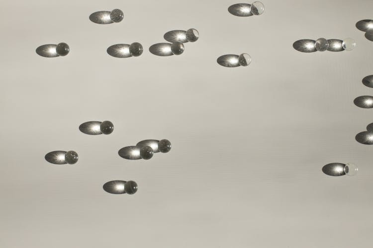 Shiny Small Balls Scattered On Table In Light Studio