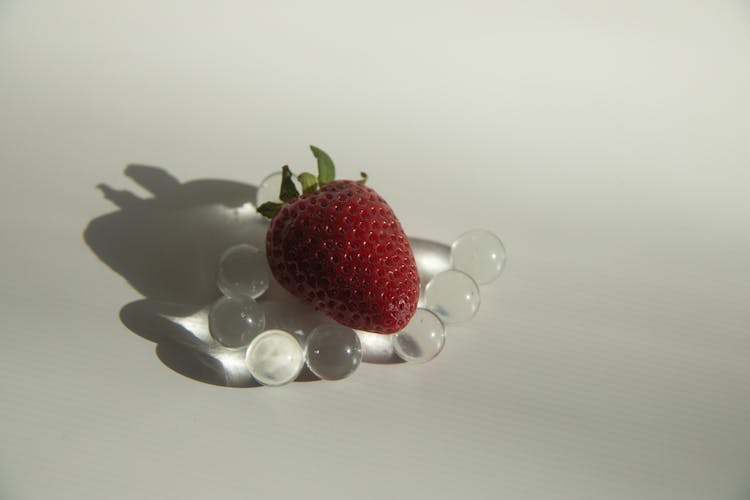 Sweet Strawberry Placed On Small Glass Balls