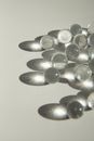 High angle of heap of small transparent glass balls scattered on white surface and shading in sunlight