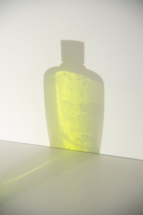 Free Shade of transparent bottle with yellow gel and smooth surface with  gray spots Stock Photo