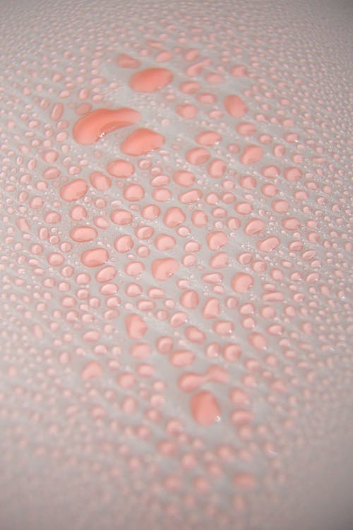 Overhead view of abstract background representing rows of smooth liquid drops with translucent surface