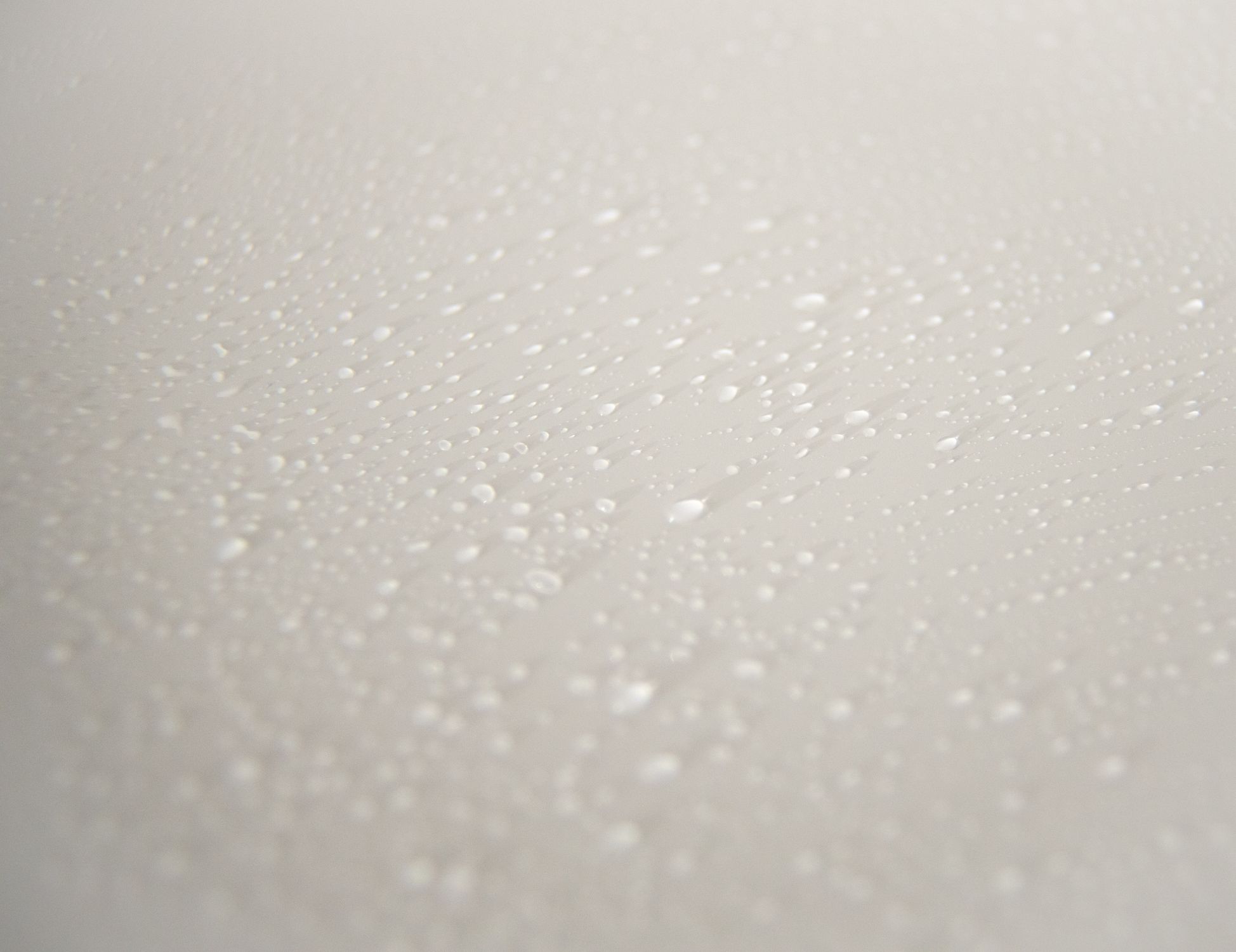 Textured background of water drops on white surface · Free Stock Photo