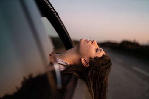A Woman Sticking Out Her Head from a Car Window