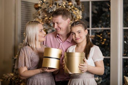 A Family Standing Near the Christmas Tree