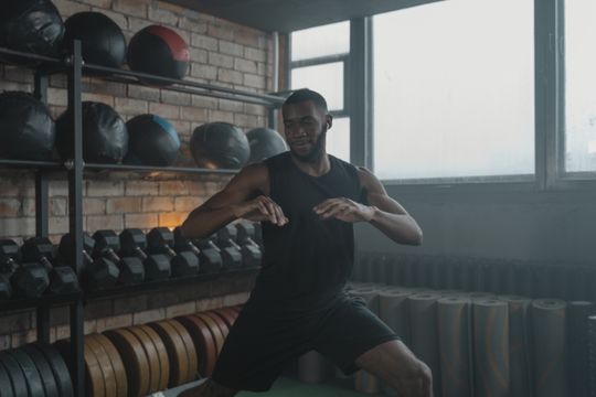 Man mid-workout surrounded by gym equipment — photo by Tima Miroshnichenko on Pexels
