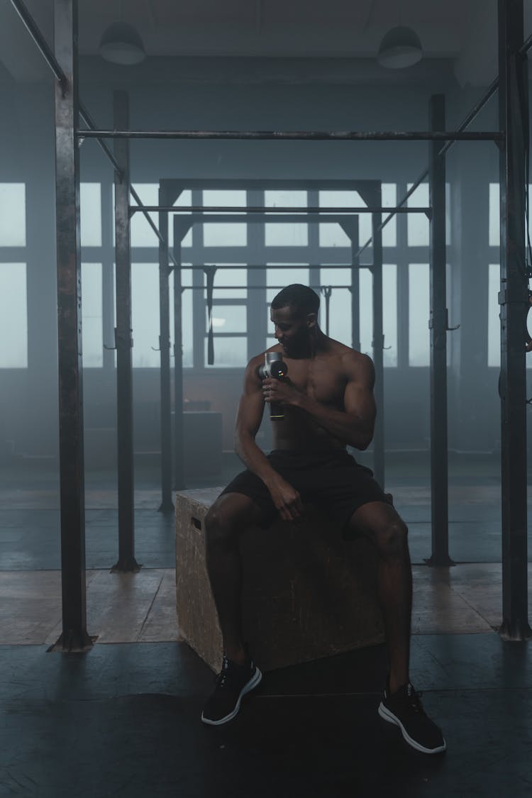 A Man Sitting Under The Pull Up Bar