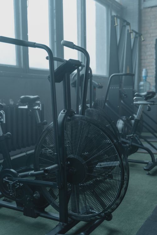 Free A set of modern exercise bikes in a spacious gym with natural light and minimalist design. Stock Photo