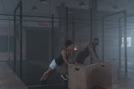 A Man and Woman in Black Tank Top Working Out Inside the Gym