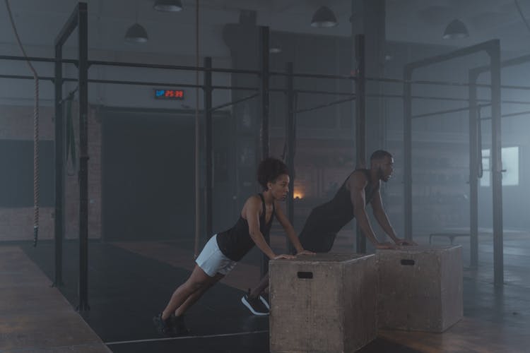 A Man And Woman In Black Tank Top Working Out Inside The Gym