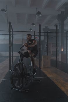A fit man working out on a stationary bike in a modern gym for healthy living.