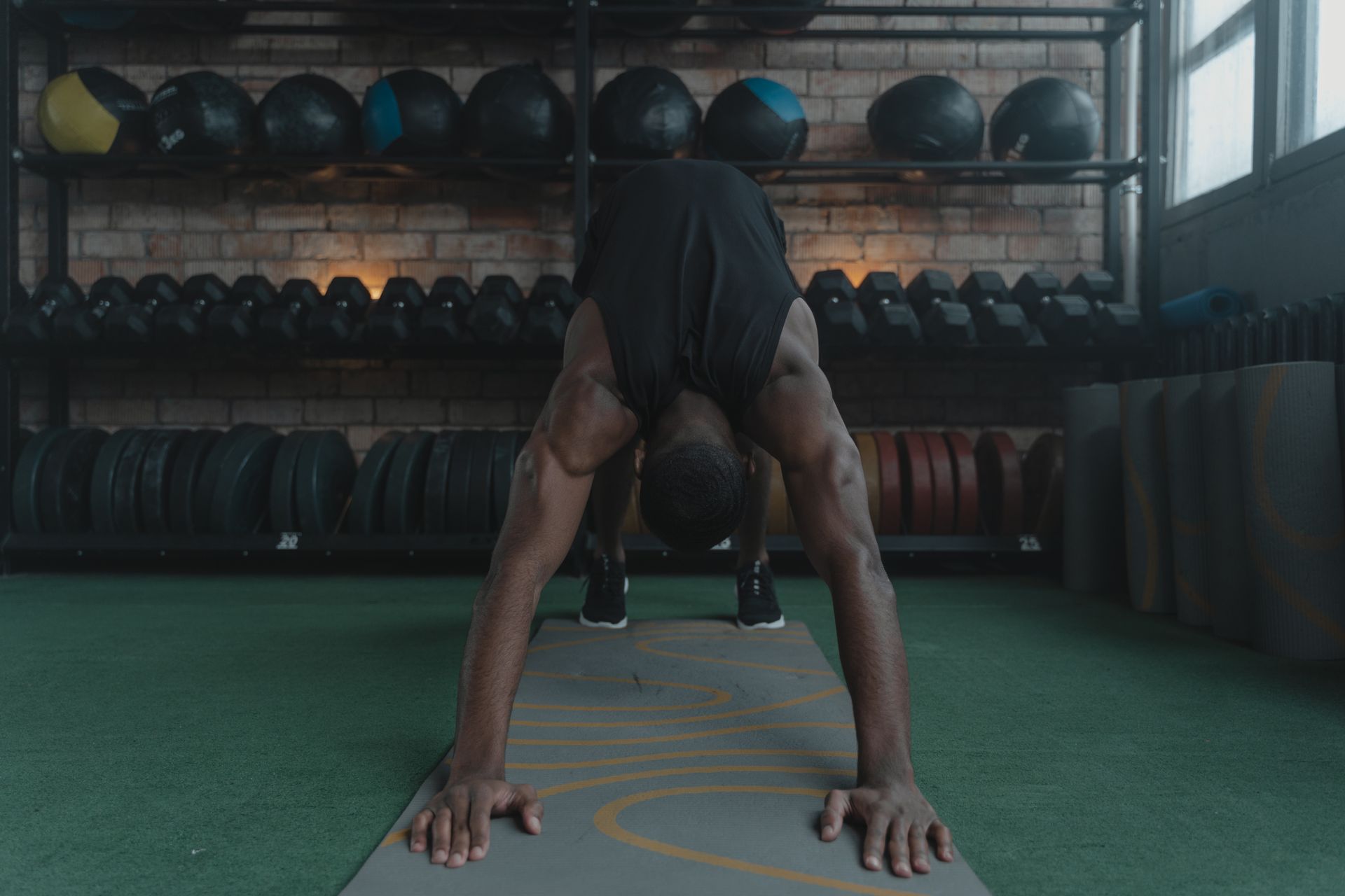 A Man Working Out with Downward Facing Dog Position