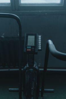 Close-up view of gym equipment with electronic monitor in a dimly lit indoor room, showcasing fitness technology.
