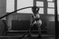 Grayscale Photo of a Woman Using Battle Ropes