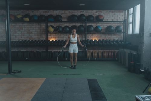 Free An athletic woman in a gym jump roping, symbolizing fitness and a healthy lifestyle. Stock Photo