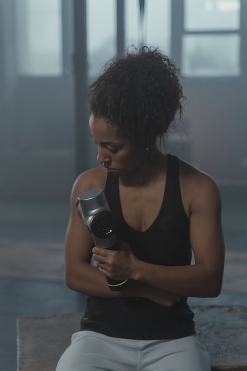 Free A Woman in Black Tank Top Exercising in the Gym Stock Photo