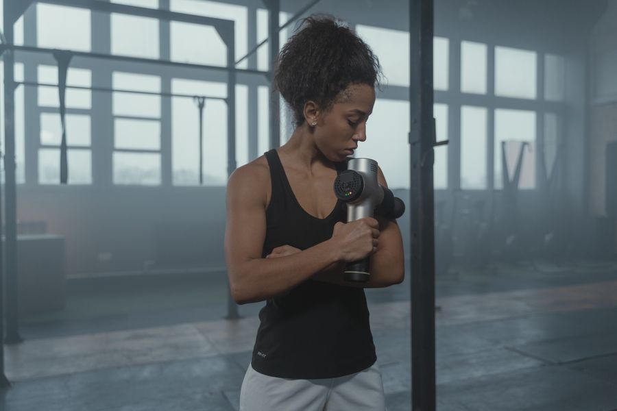 Athlete using a massage device after exercise