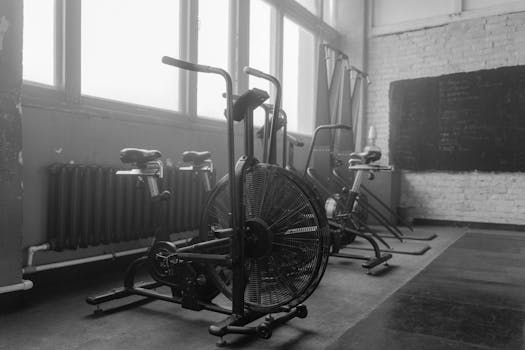 Black and white gym interior featuring exercise bikes and fitness equipment.