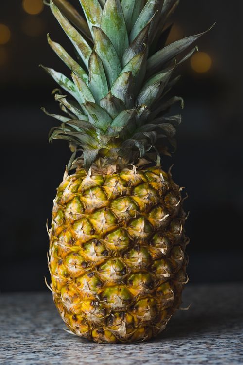 Free Close-up of a ripe pineapple on a marble table. Perfect tropical fruit imagery. Stock Photo