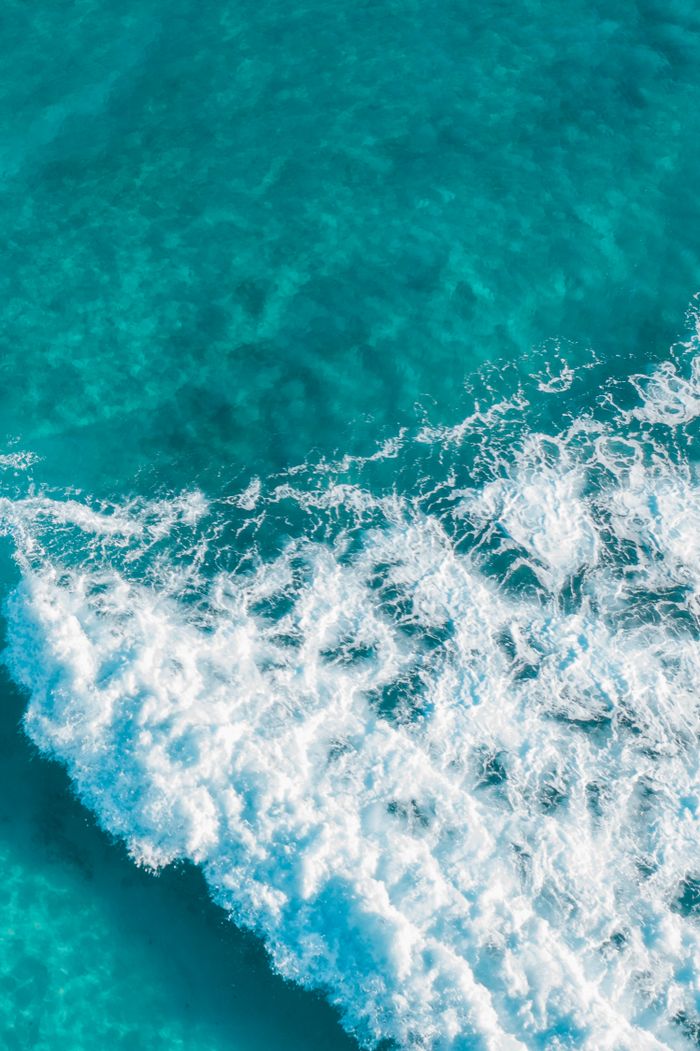 Aerial view of turquoise ocean waves — photo by Jess Loiterton on Pexels