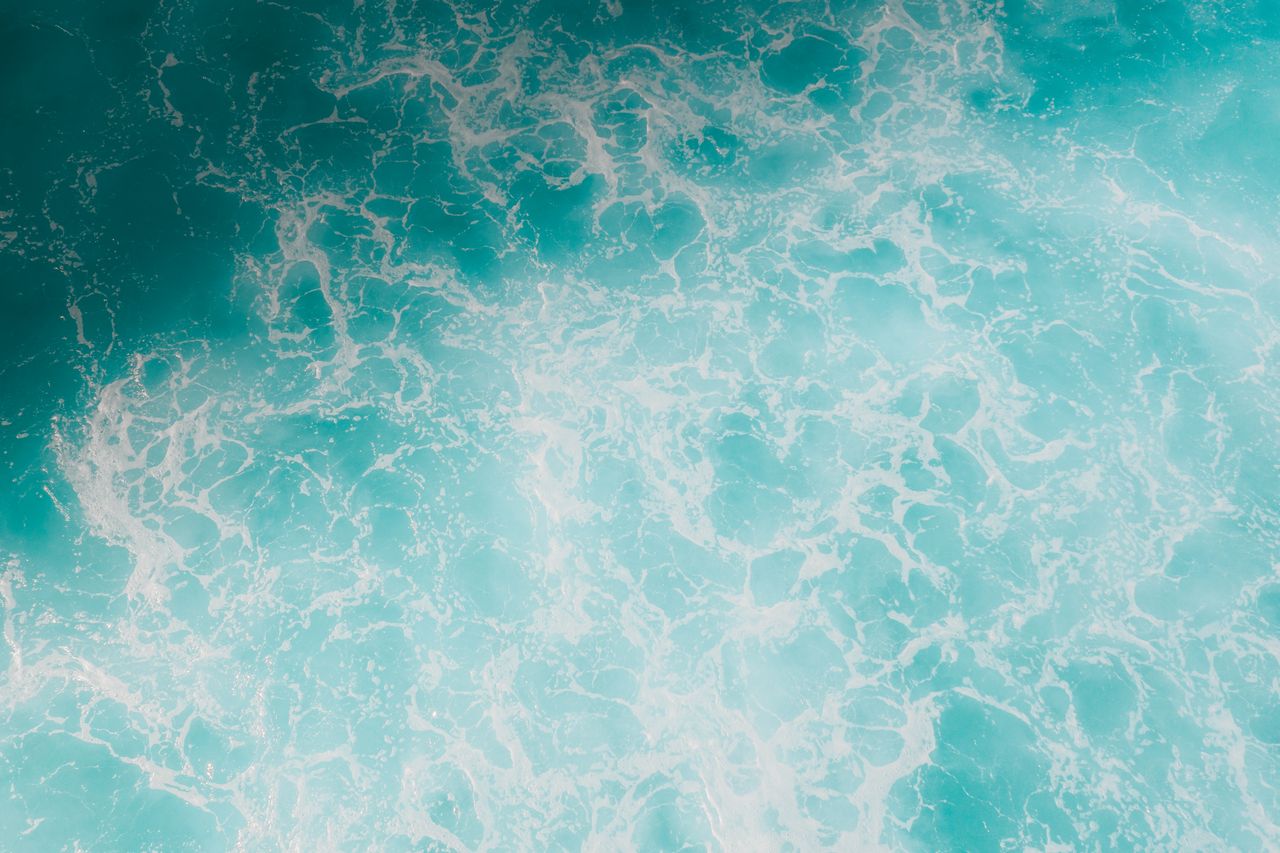 captivating aerial shot of turquoise ocean waves with frothy seafoam s