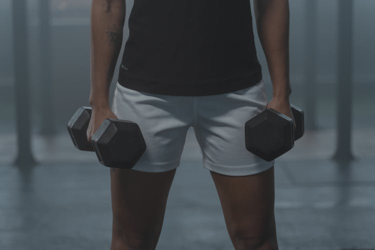 
A Tattooed Person Holding Dumbbells