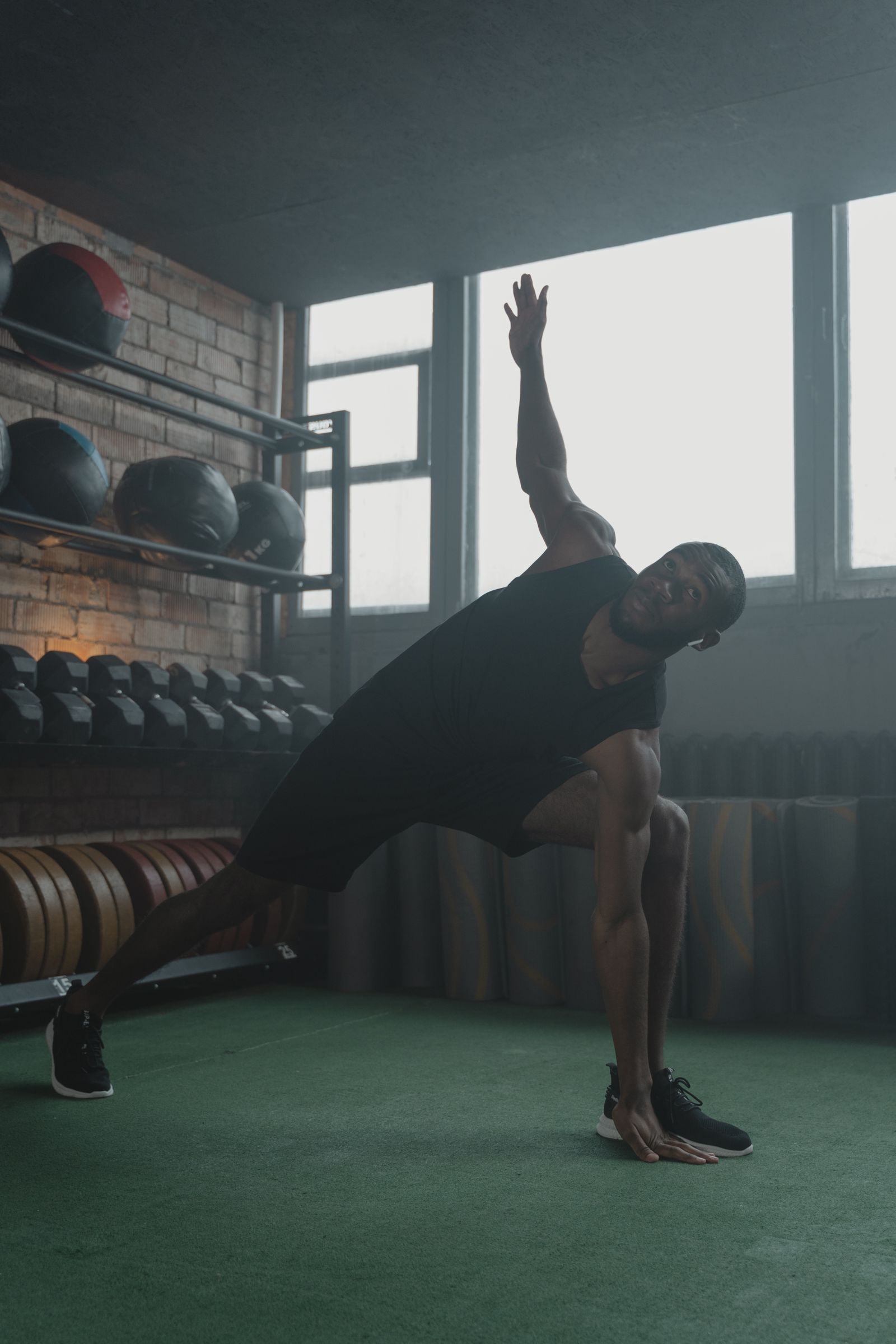 Athletic person stretching in a gym, representing training and recovery.