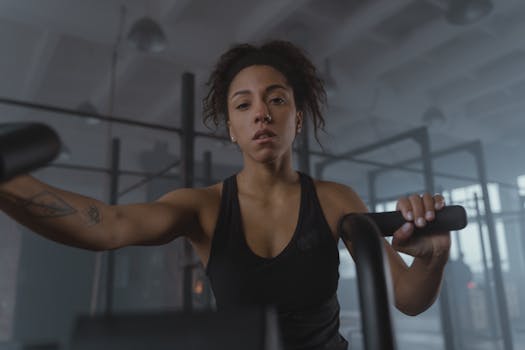 Young African American woman intensely working out on an exercise bike indoors.