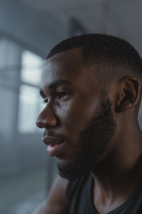 Free Close-up profile of a pensive bearded man indoors with natural soft lighting. Stock Photo