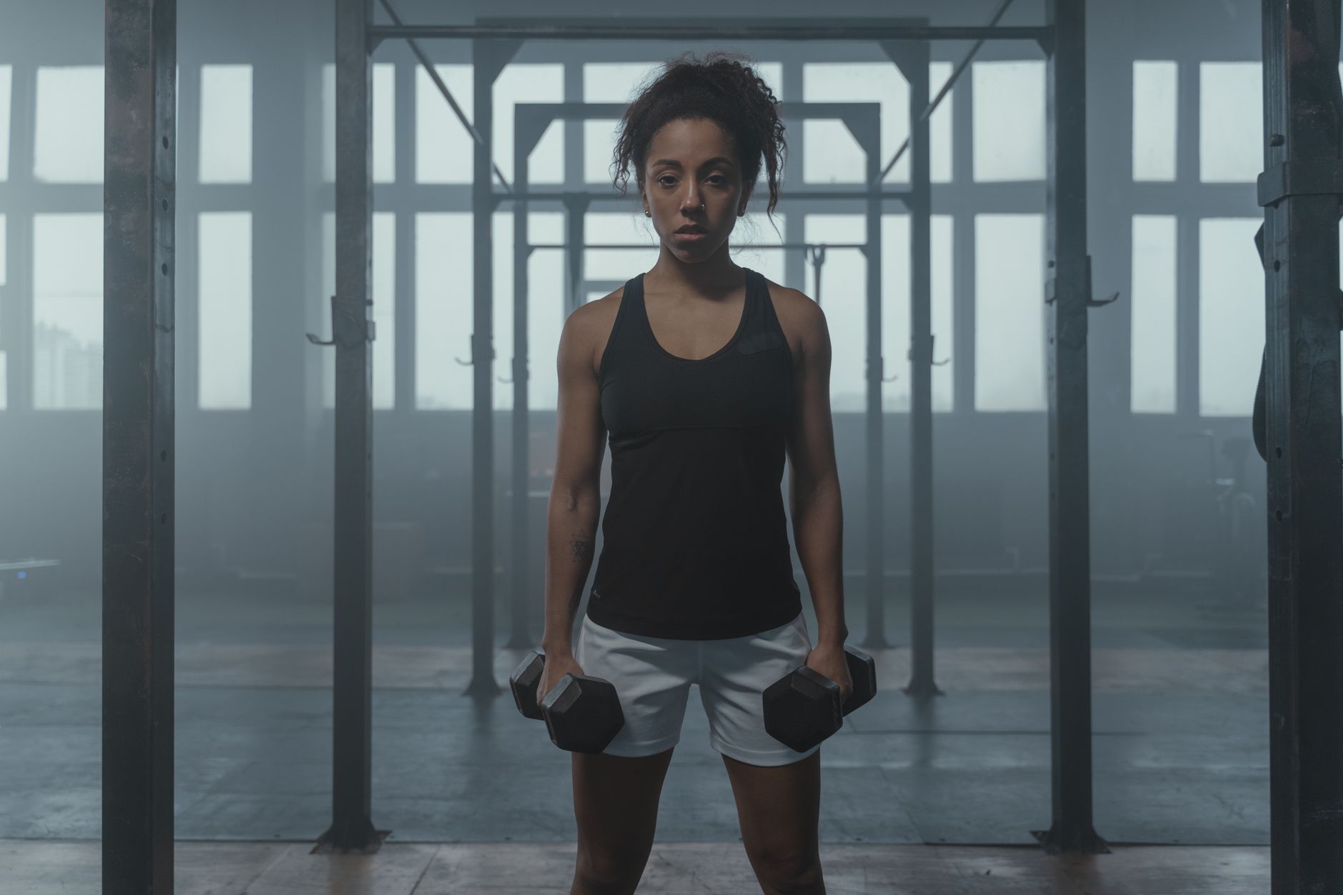 健美選手心靈修練:日常管理技巧提升表現 Determined woman lifting weights, showcasing fitness and strength in a gym setting.