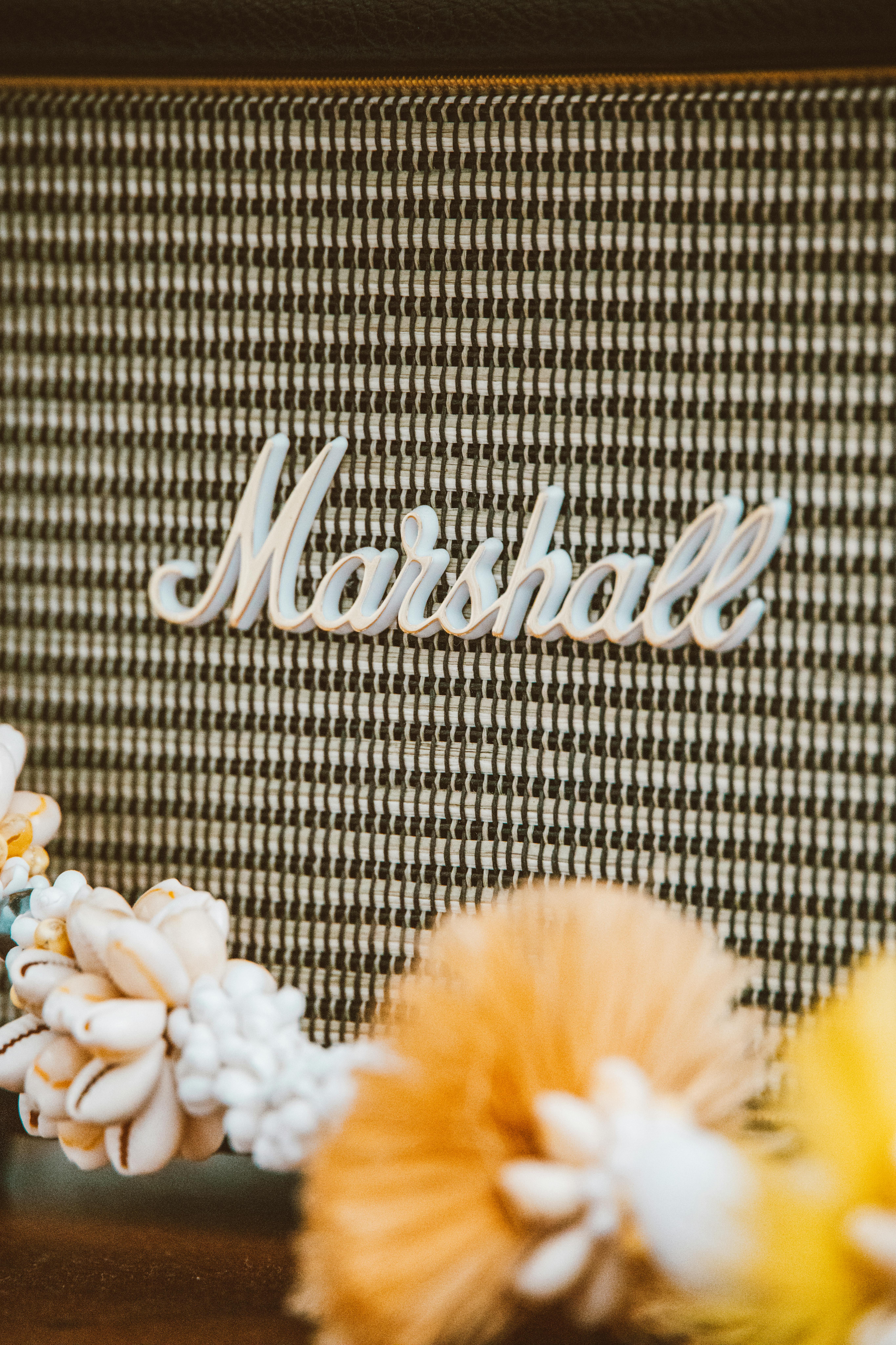 A vintage Marshall speaker adorned with decorative floral elements in a soft focus close-up.