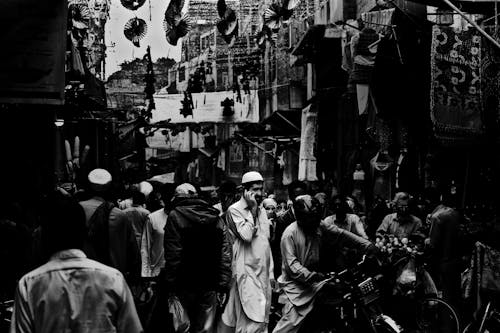 Monochrome Shot of a Man Standing on a Crowded Street