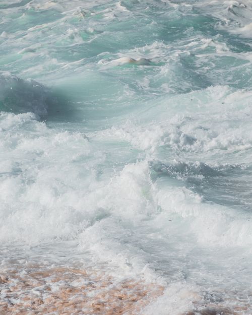 Free Vibrant sea waves crashing upon a sandy shore, capturing nature's vibrant motion and energy. Stock Photo