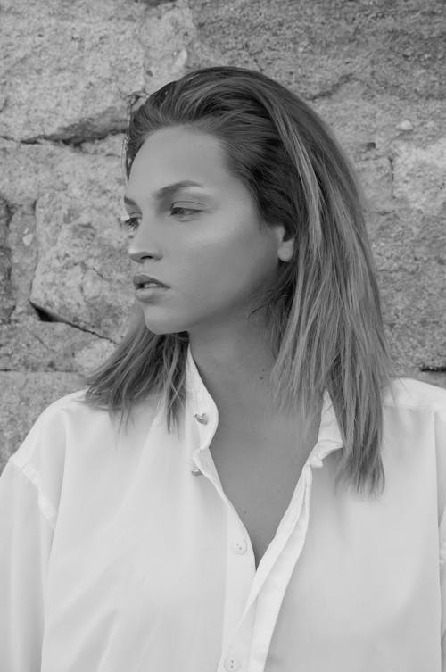 Dreamy model in white shirt against stone surface