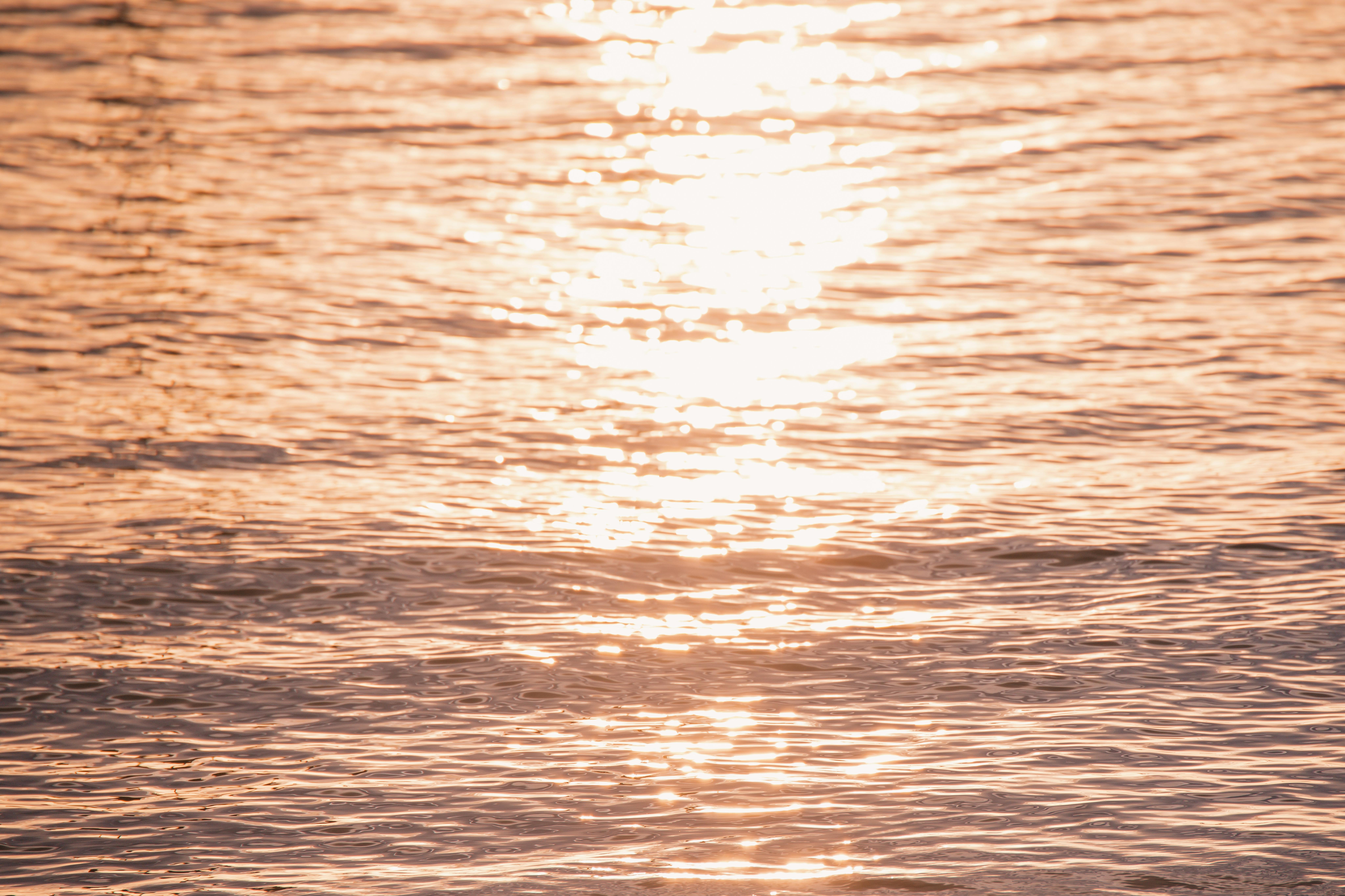 宁静的日落倒映在海浪上，营造出温暖、宁静的氛围