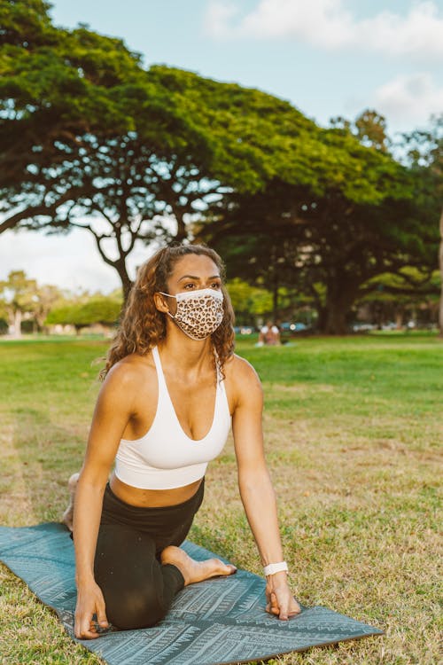 Young Woman in Mask Performing Yoga Stretching Exercise