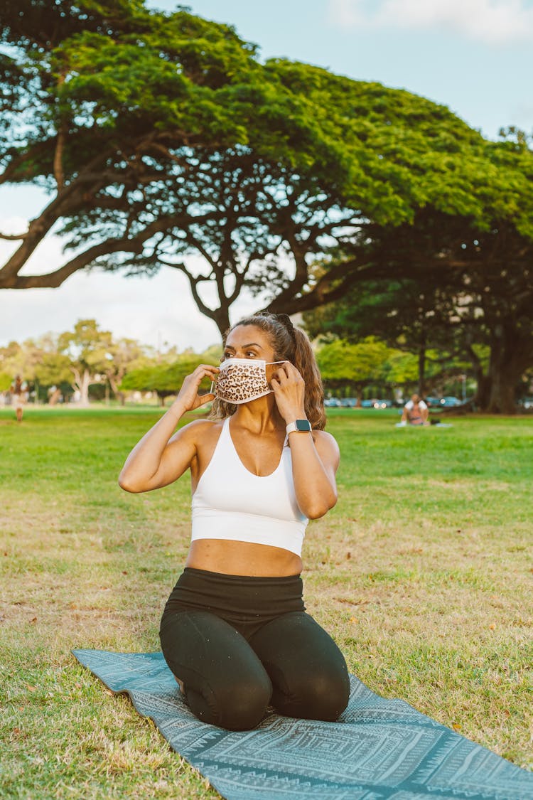 Woman In Park Covering Nose And Mouth With Mask 