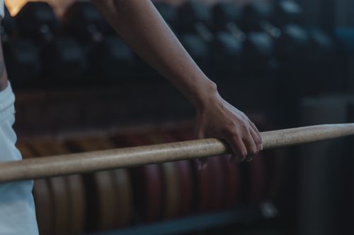 Free Detailed view of an athlete's hand gripping a barbell, showcasing strength and focus in a gym setting. Stock Photo