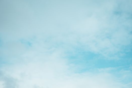 A tranquil scene of a blue sky filled with light, fluffy clouds.