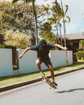 Skateboarder performing an ollie on a sunny day in a suburban neighborhood.