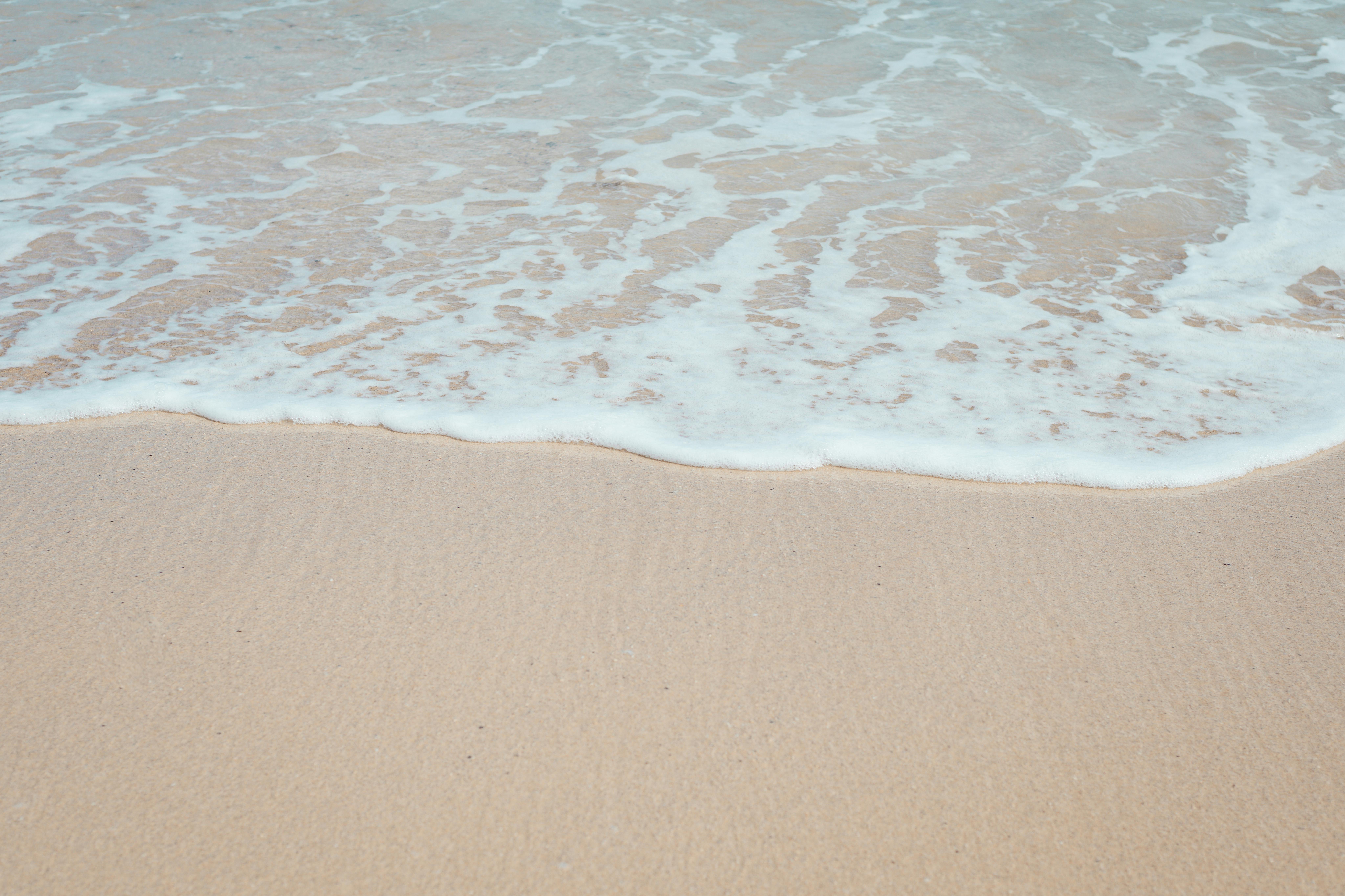 平静的海浪轻轻拍打在沙滩上，非常适合自然主题