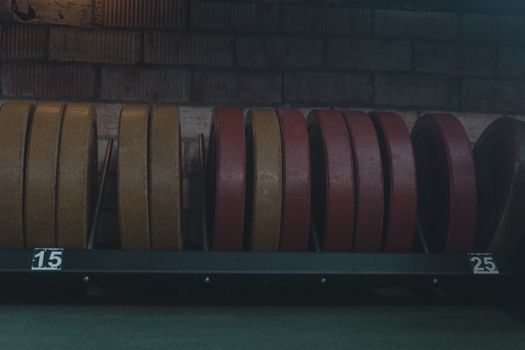 Detailed view of gym weight plates on a rack in an indoor fitness center.