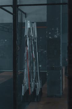 Dark and moody gym interior featuring stacked barbells and rugged industrial design.