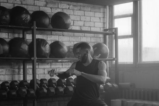 Black and white photo of a man working out in the gym, focusing on fitness and strength.