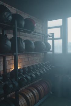 A dimly lit gym with fitness equipment and brick walls, creating a rustic ambiance.